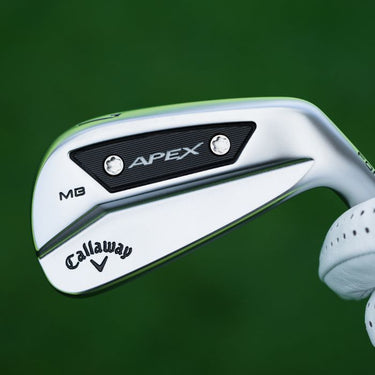 Callaway Apex MB 24 Golf Irons with a grass background being held by the hosle, with the back of the club head showing.